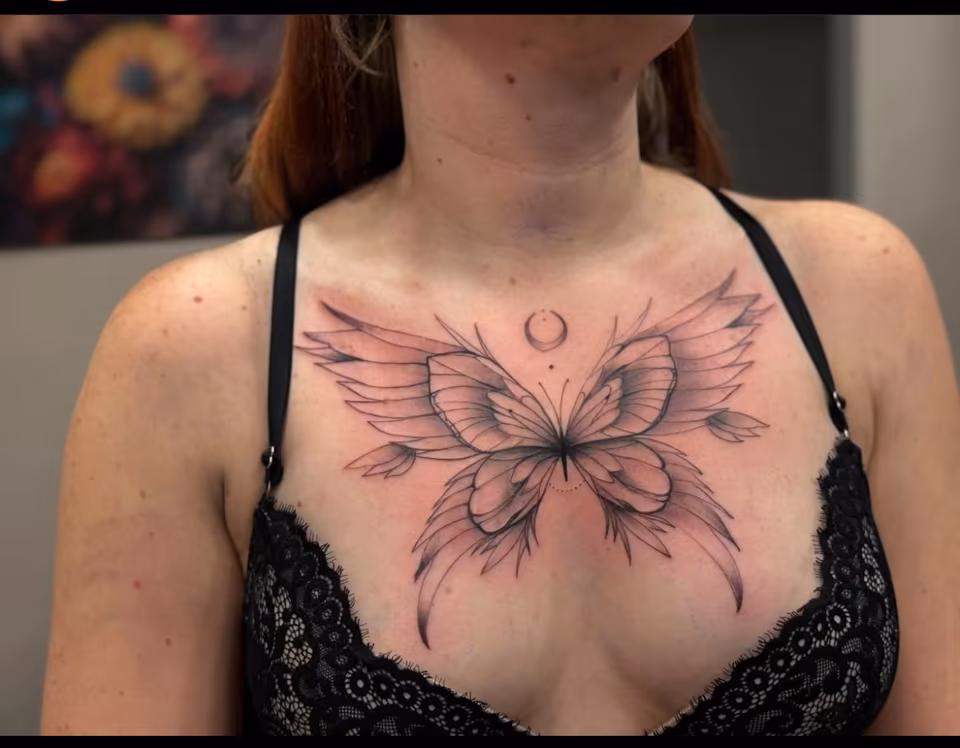 Großer Schmetterling in feinen Linien auf dem Dekolleté