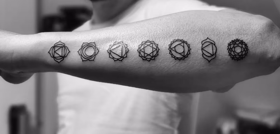 Sieben Chakra-Symbole in einer Reihe am Unterarm