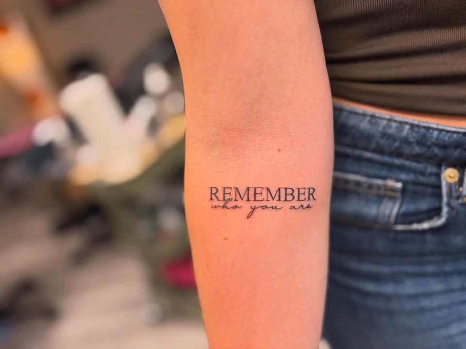 Schriftzug REMEMBER who you are aus Serifen- und Schreibschrift am Unterarm